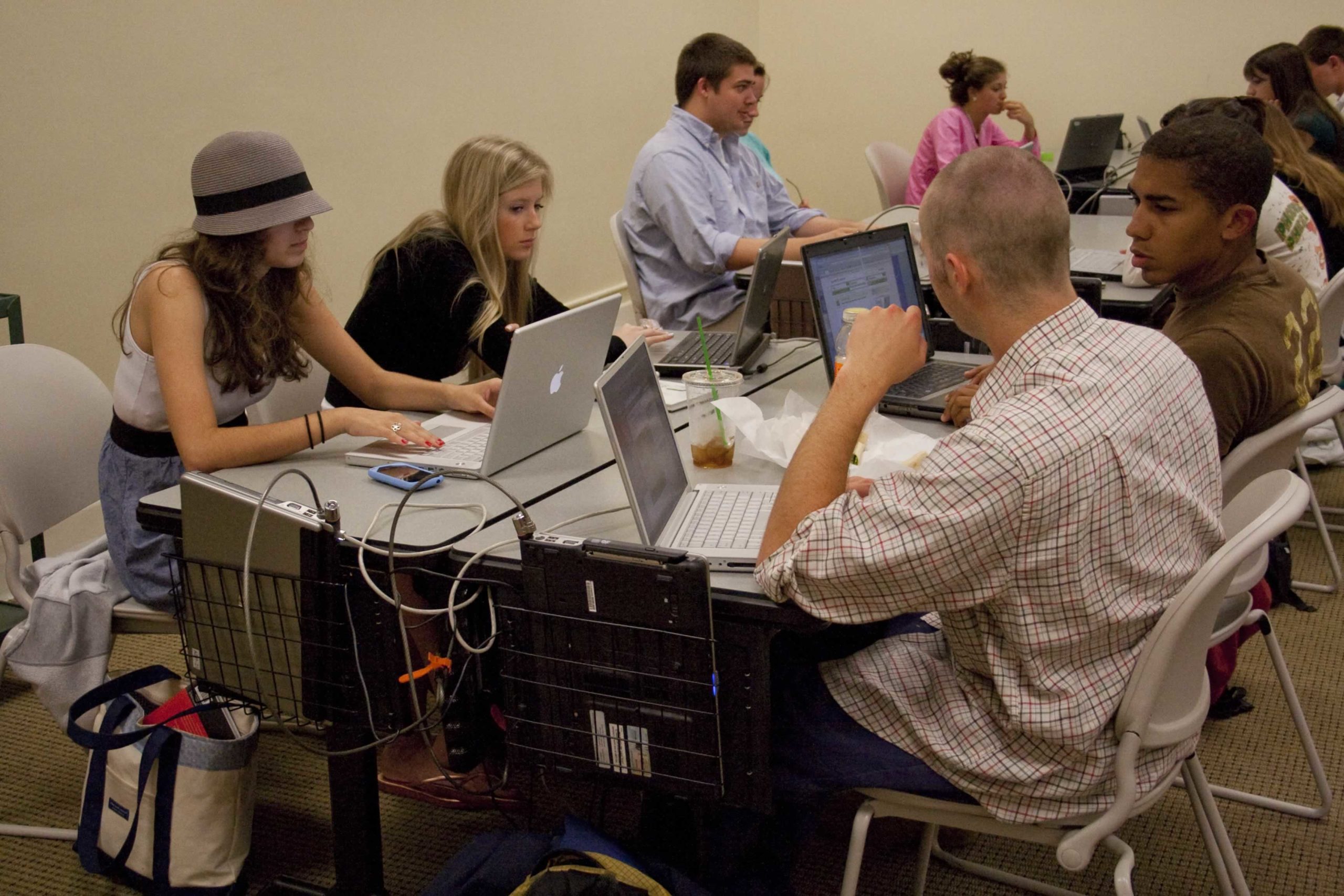 Students writing in a laptop classroom.