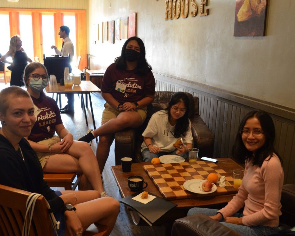 A group of students and faculty work together in a coffee shop