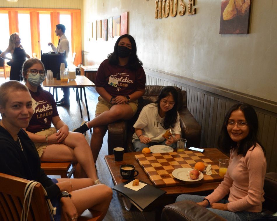 A group of students and faculty work together in a coffee shop