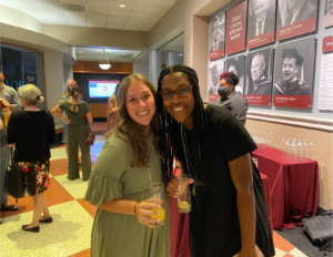 Two young women pose for a photo at a reception.