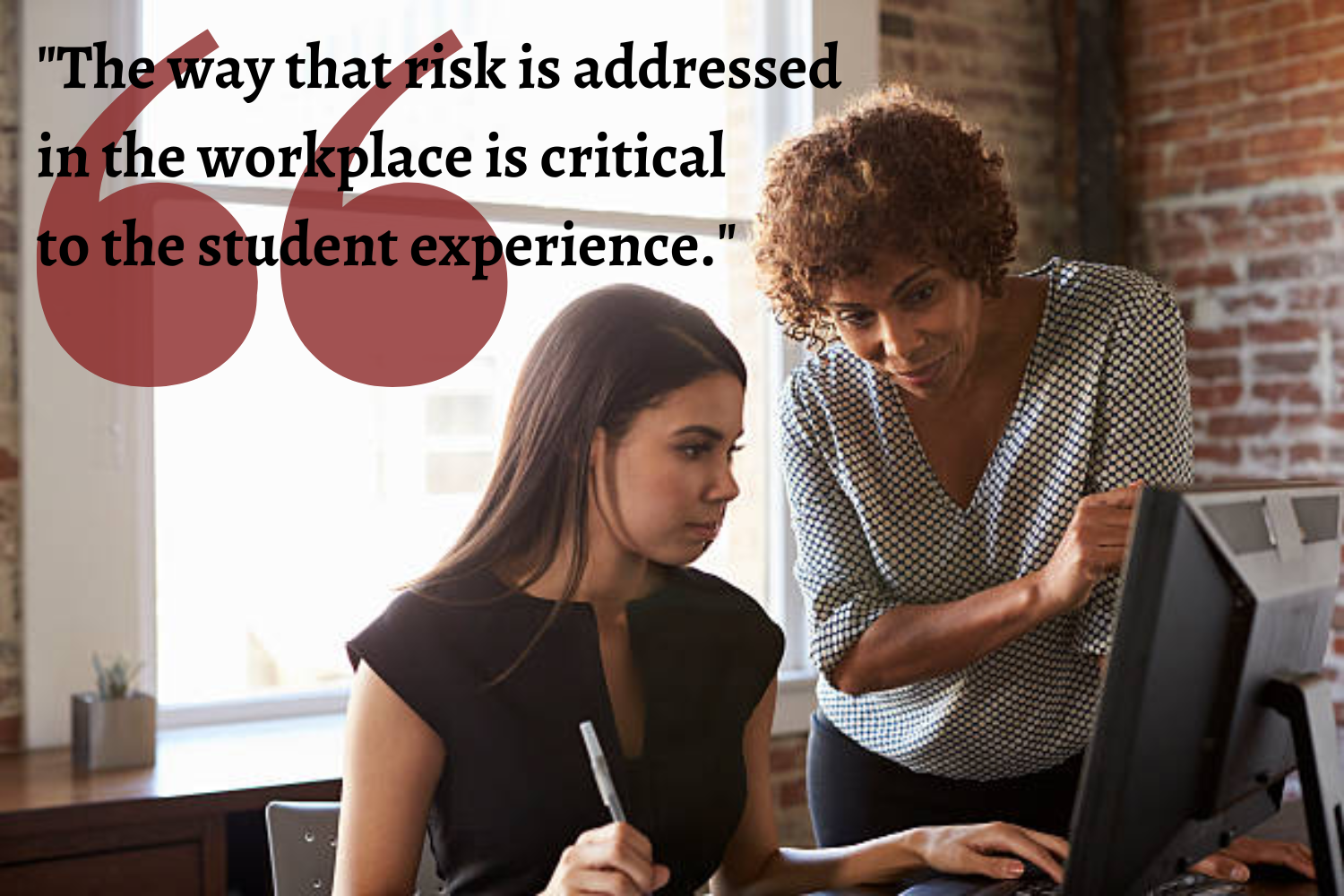 Two women stand near a window, looking down at a computer. "The way that risk is assessed in the workplace is critical to the student experience."