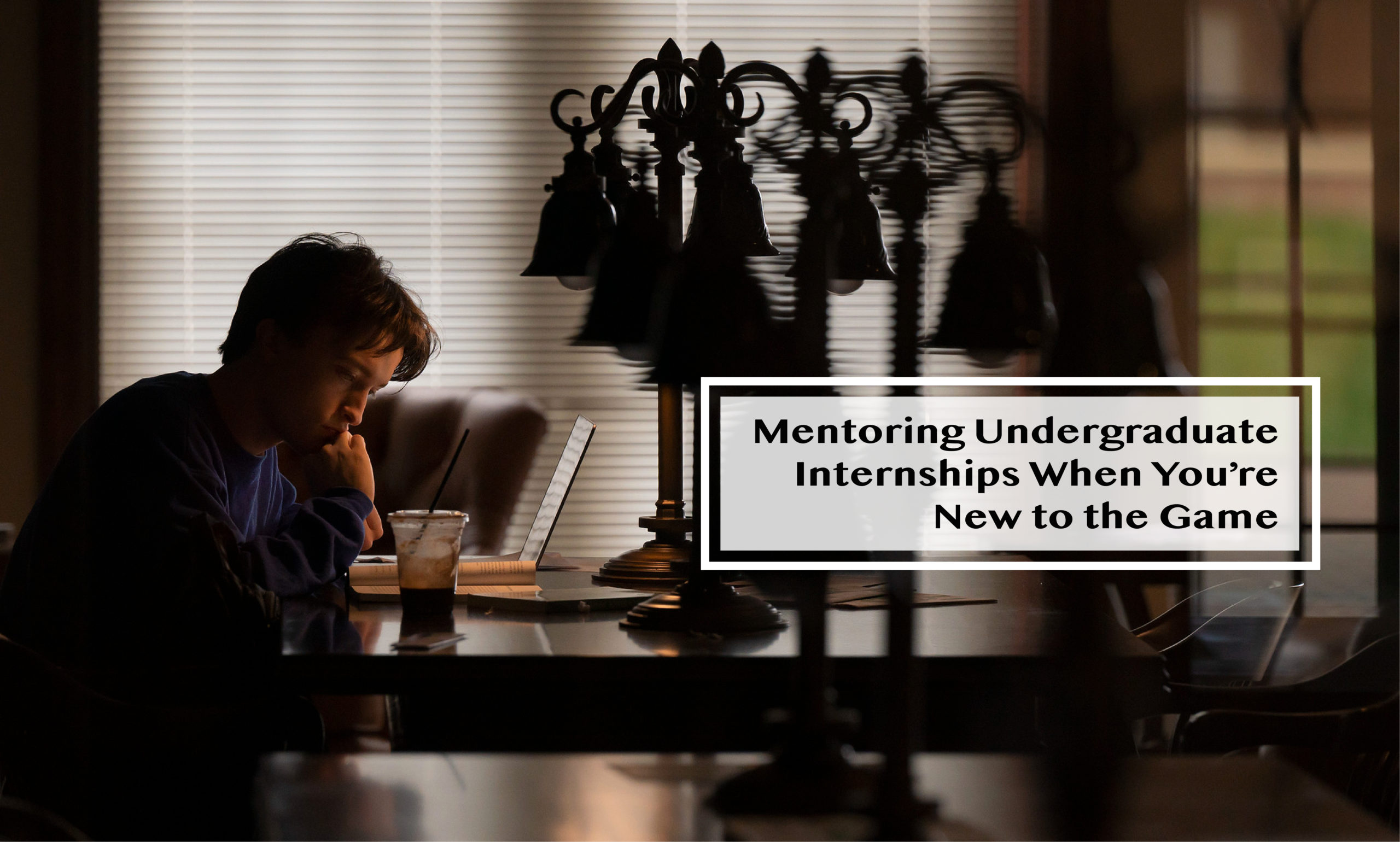 Light-skinned male student works on his laptop while drinking his iced coffee "Mentoring Undergraduate Internships When You're New to the Game"