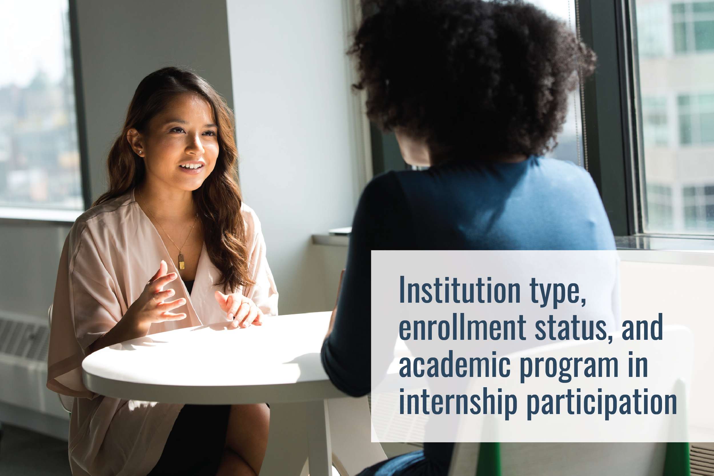 Two people sit at a small round table, talking. Several windows are nearby, and you can see a city view. Text overlay says, "Institution type, enrollment status, and academic program in internship participation"