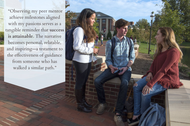 Three students sit outside on Elon's campus having a lively conversation.