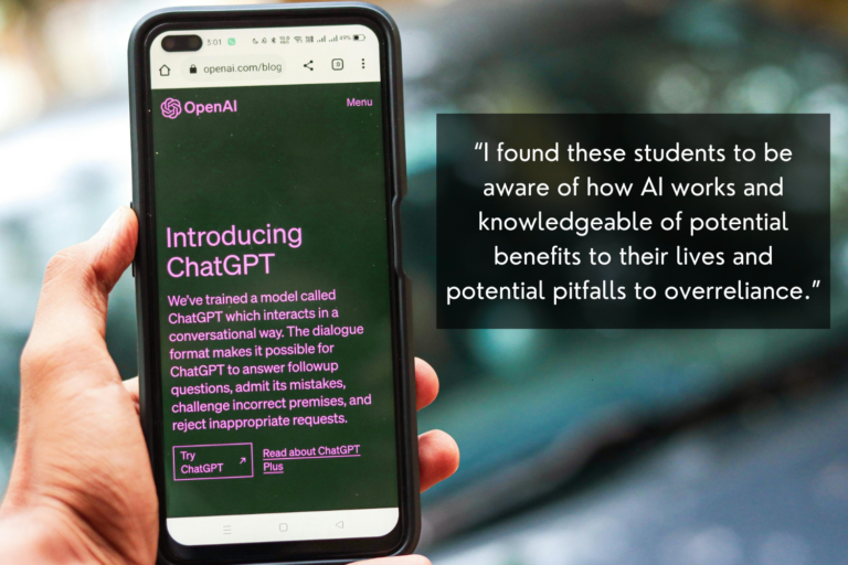 Image of a person's hand holding up a phone displaying OpenAI's website home page, which reads: "Introducing ChatGPT. We've trained a model called ChatGPT which interacts in a conversational way. The dialogue format makes it possible for ChatGPT to answer followup questions, admit its mistakes, challenge incorrect premises, and reject inappropriate requests." An accompanying quote from the blog post says the following: "I found these students to be aware of how AI works and knowledgeable of potential benefits to their lives and potential pitfalls to overreliance."