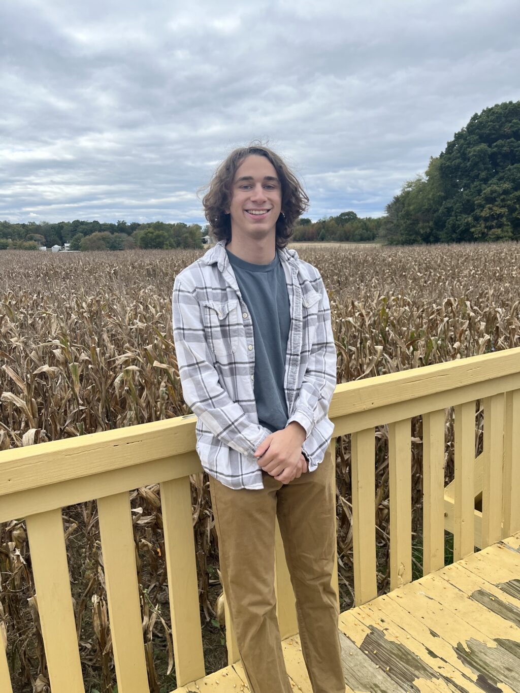 Photo of Ben Krasnow standing on a deck in front of a field of corn