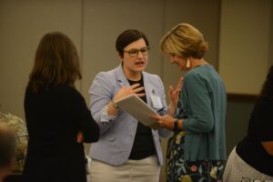 Three women engage in conversation at a Center for Engaged Learning conference
