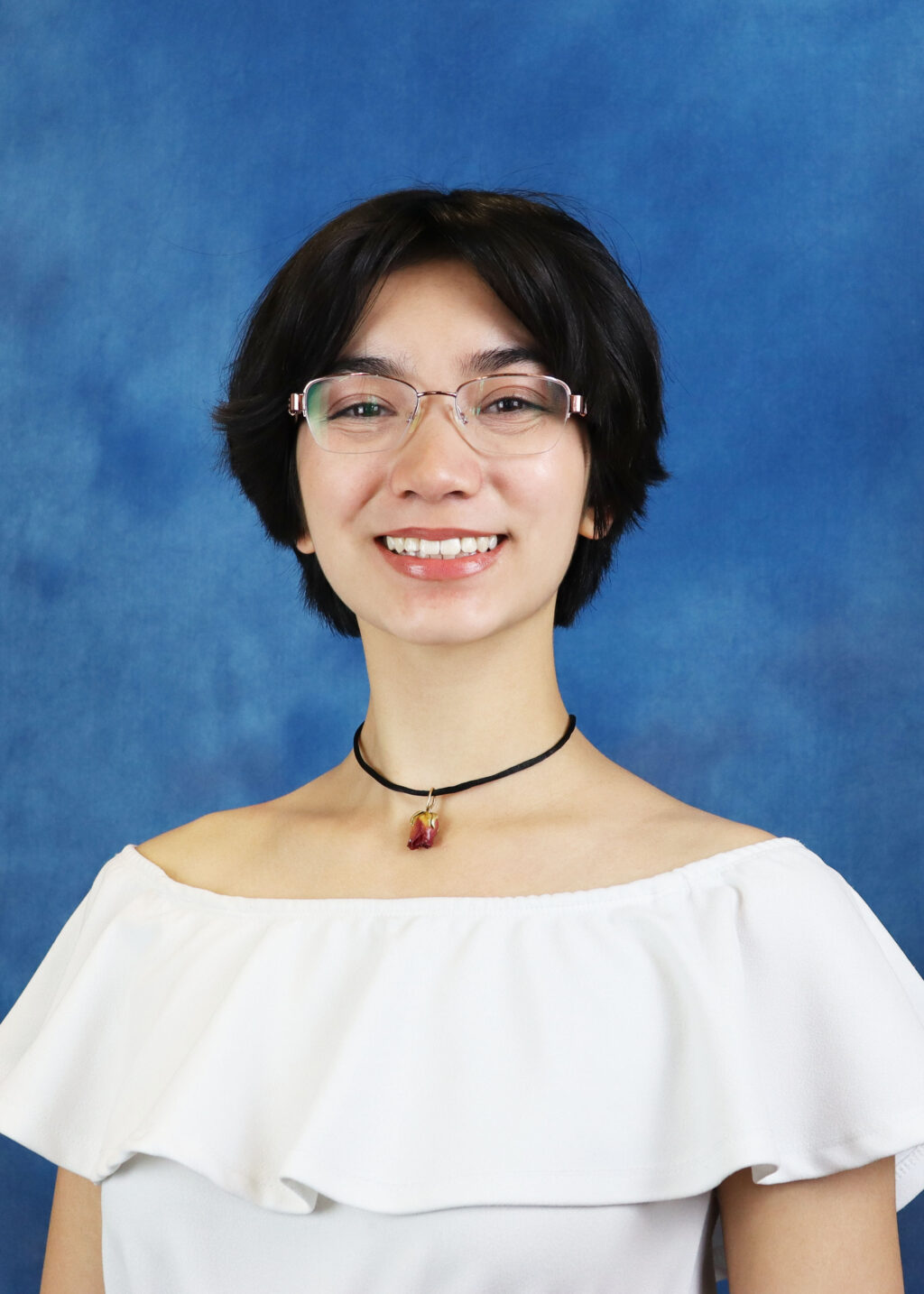 A portrait of Sophia Sta. Rosa. She is a young woman of Filipino and Ashkenazi Jewish heritage with glasses and short dark hair.