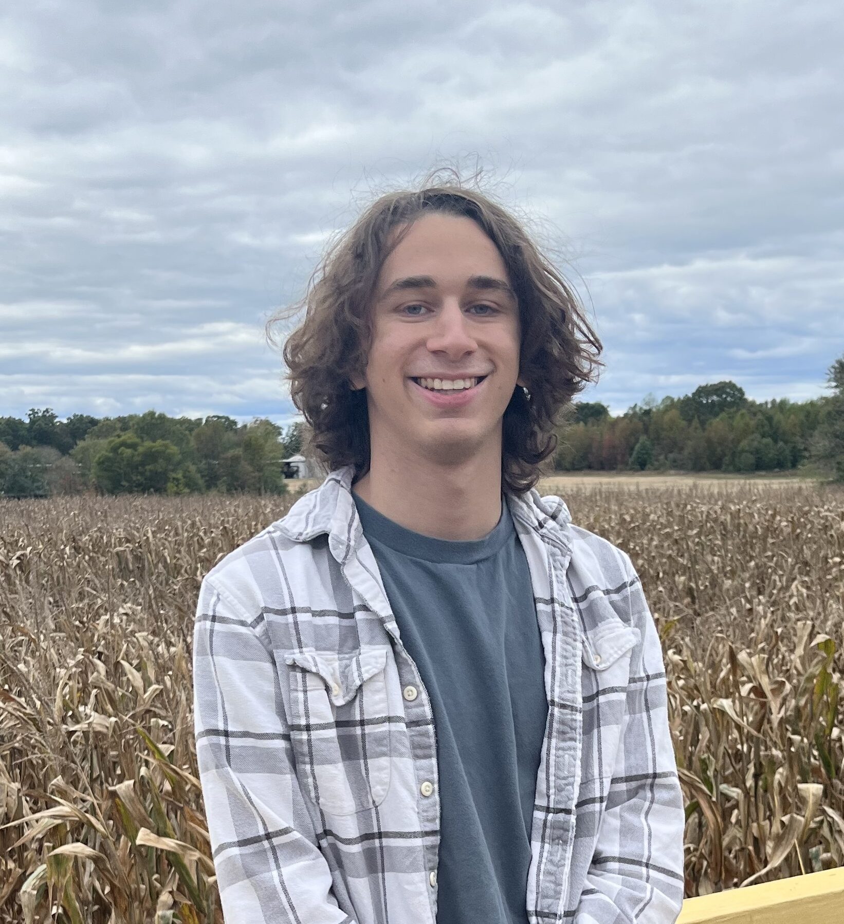 Photo of Ben Krasnow standing on a deck in front of a field of corn